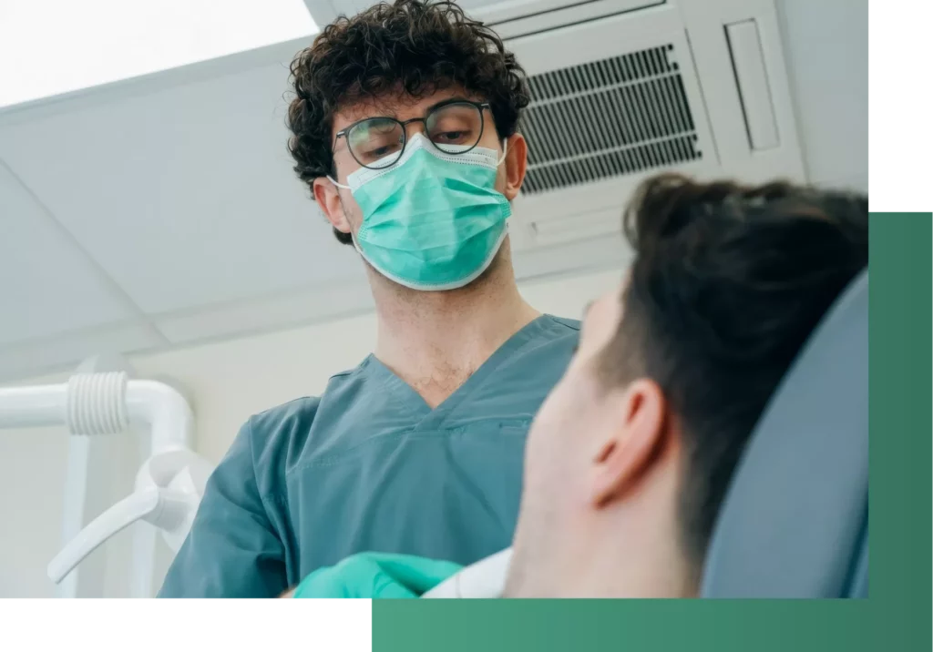 Zahnarzt untersucht Patienten im Stuhl