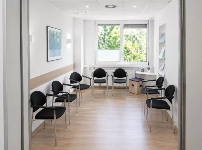 Helles, modernes Wartezimmer mit Stühlen.