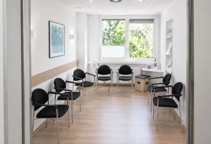 Helles, modernes Wartezimmer mit Stühlen.