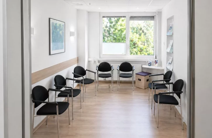 Helles, modernes Wartezimmer mit Stühlen.